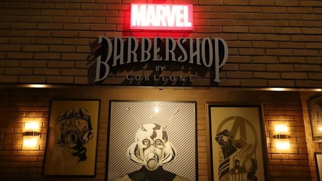 Ingresso della Marvel Barbershop by Corleone con logo luminoso e immagini tematiche Marvel sulle pareti.