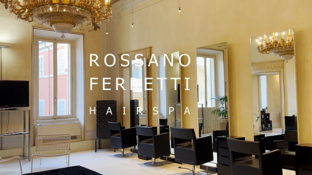 Interno del salone Rossano Ferretti Hairspa a Parma con arredi eleganti, specchi moderni e un grande lampadario dorato.