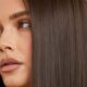 Capelli lisci e luminosi con effetto naturale, dettaglio su una donna con capelli castani perfettamente stirati.