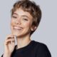 Donna sorridente con taglio di capelli corto scalato Shixie, un mix tra shag e pixie.