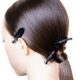 Capelli lisci e lucidi raccolti in una coda bassa con clip nere da backstage