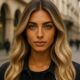 Modella con capelli biondo vaniglia, carnagione olivastra e occhi azzurri in posa fashion a Milano