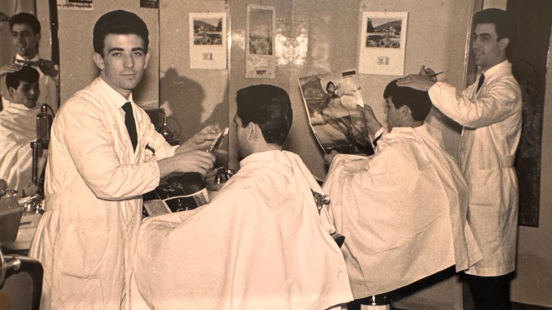Barbieri al lavoro in un salone negli anni '60, in un'immagine d'archivio in bianco e nero