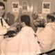 Barbieri al lavoro in un salone negli anni '60, in un'immagine d'archivio in bianco e nero