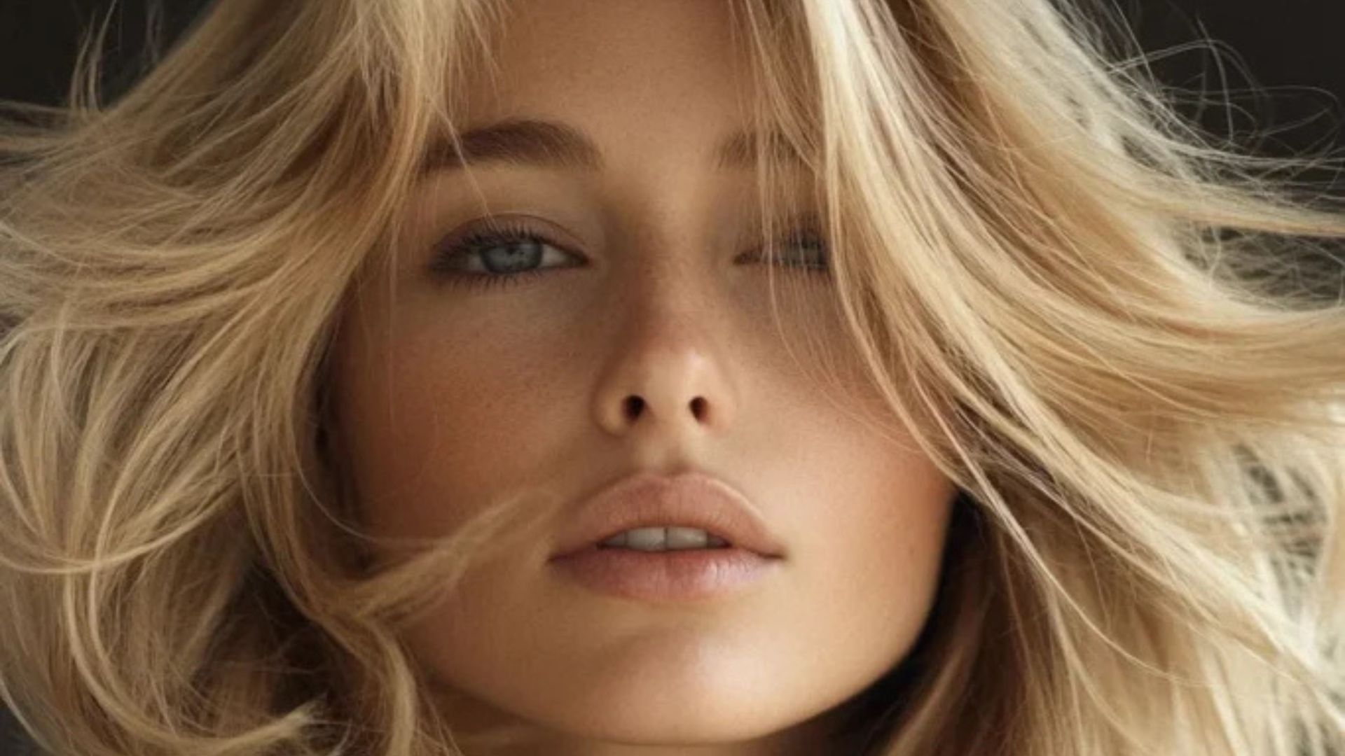 Ritratto ravvicinato di donna con capelli Champagne Blonde, onde morbide e look luminoso