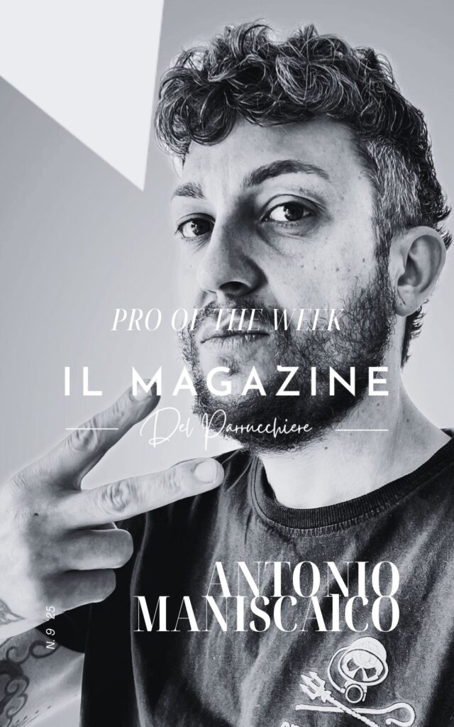 Ritratto in bianco e nero di Antonio Maniscalco, acconciatore selezionato come "Pro of the Week" da Il Magazine del Parrucchiere, mentre fa il segno della vittoria con le dita e guarda in camera con espressione sicura.