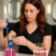 Parrucchiera in salone misura il pH di una soluzione cosmetica con strumenti da laboratorio e becher colorati