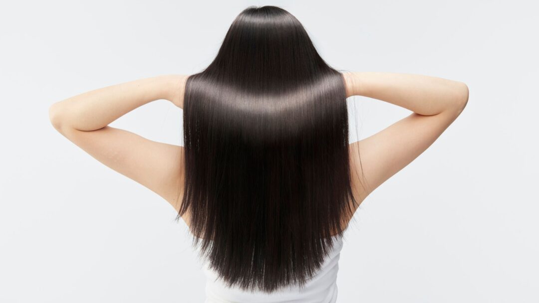 Capelli lisci e lucenti dopo un trattamento di nanoplastia, visti da dietro.