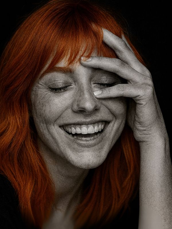 Donna sorridente con capelli copper soft, fotografia in bianco e nero con capelli colorati in rame luminoso, tendenza capelli autunno 2025.
