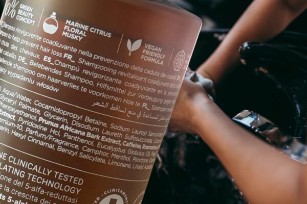 Dettaglio del flacone Fortify Shampoo di Roverhair con simboli e ingredienti, utilizzato in salone professionale durante il lavaggio capelli.