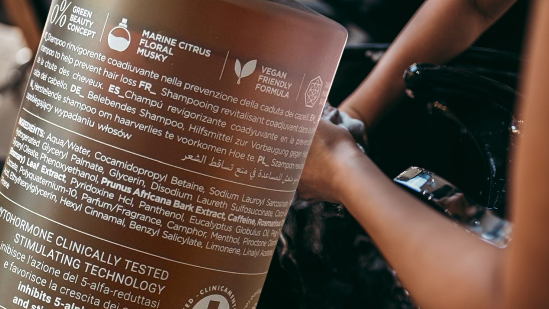 Dettaglio del flacone Fortify Shampoo di Roverhair con simboli e ingredienti, utilizzato in salone professionale durante il lavaggio capelli.