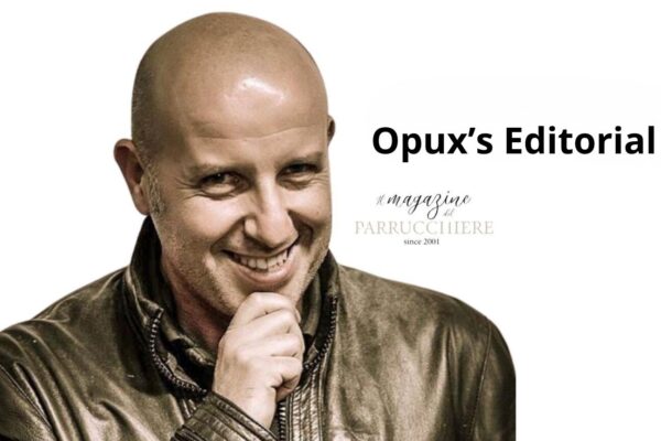 Smiling bald man in a leather jacket, hand on chin, on a white background with the headline “Opux’s Editorial” and the faint “Il Magazine del Parrucchiere (since 2001)” logo.