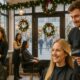 Salone di parrucchieri decorato per Natale con professionisti al lavoro e clienti sorridenti, illuminazione calda e atmosfera festiva.