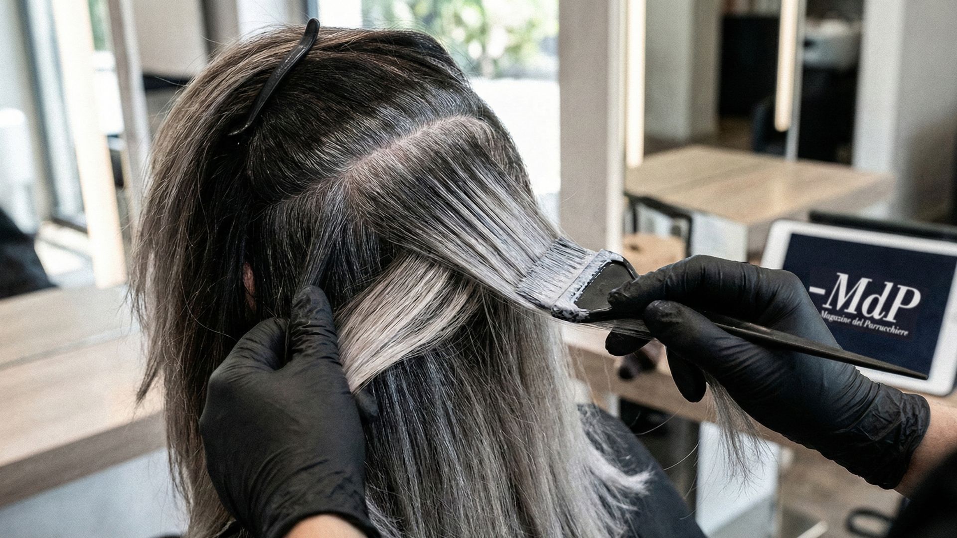 Applicazione tecnica di Grey Blending in salone su capelli con alta percentuale di bianchi, con tablet MdP sullo sfondo.