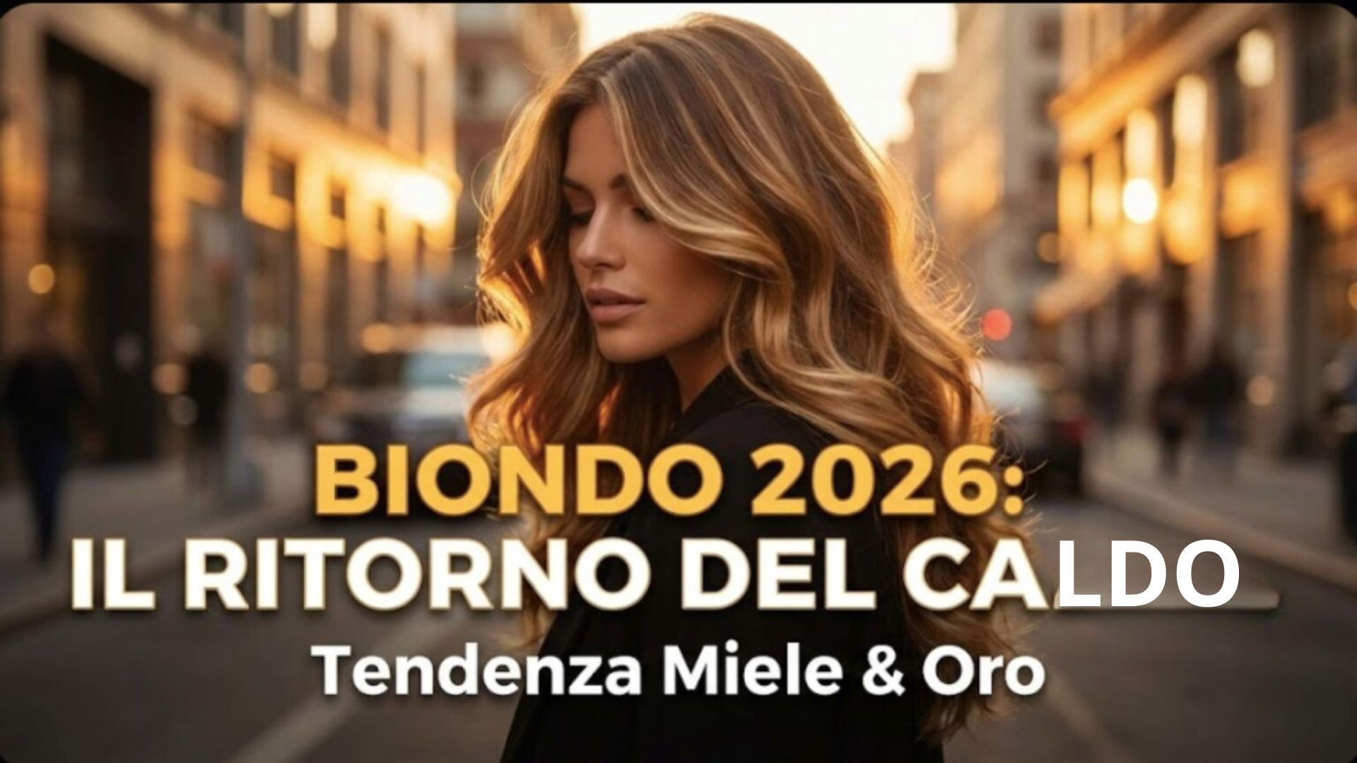 Immagine di copertina con una donna dai capelli balayage miele e oro al tramonto in città. Testo sovrapposto: "BIONDO 2026: IL RITORNO DEL CALDO - Tendenza Miele & Oro".