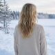 Rear view of blonde hair with soft, deconstructed beach waves styling against a blurred snowy winter landscape, highlighting natural texture.