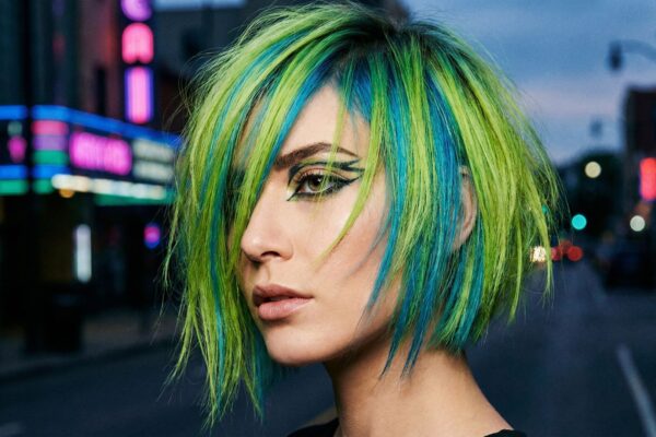 Taglio corto sfilato con colorazione creativa neon verde acido e blu elettrico, trend capelli Gen Z 2026 e stile urban cyberpunk.
