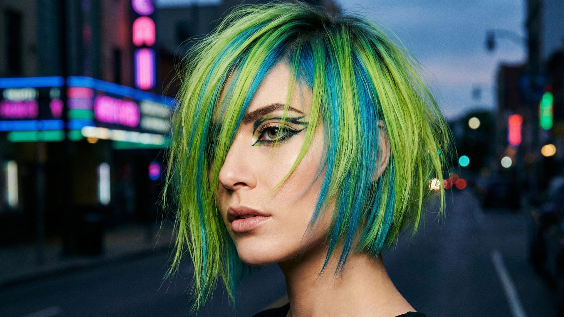 Taglio corto sfilato con colorazione creativa neon verde acido e blu elettrico, trend capelli Gen Z 2026 e stile urban cyberpunk.