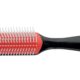 Spazzola professionale Denman D3 a 7 file con manico nero e cuscinetto rosso per lo styling dei capelli ricci.