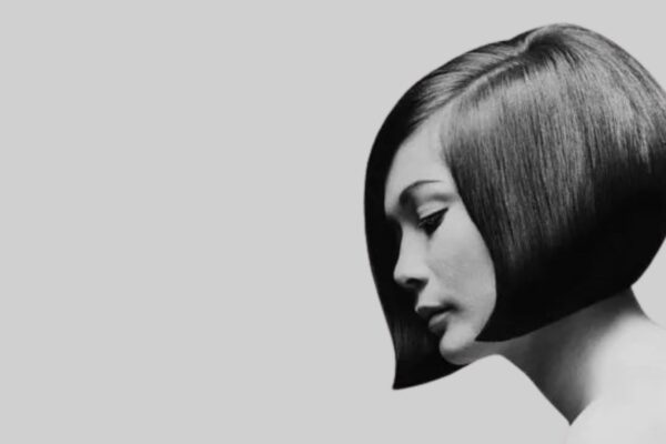 Profilo di una donna in bianco e nero con un iconico caschetto geometrico a punta, ispirazione Vidal Sassoon anni '60.
