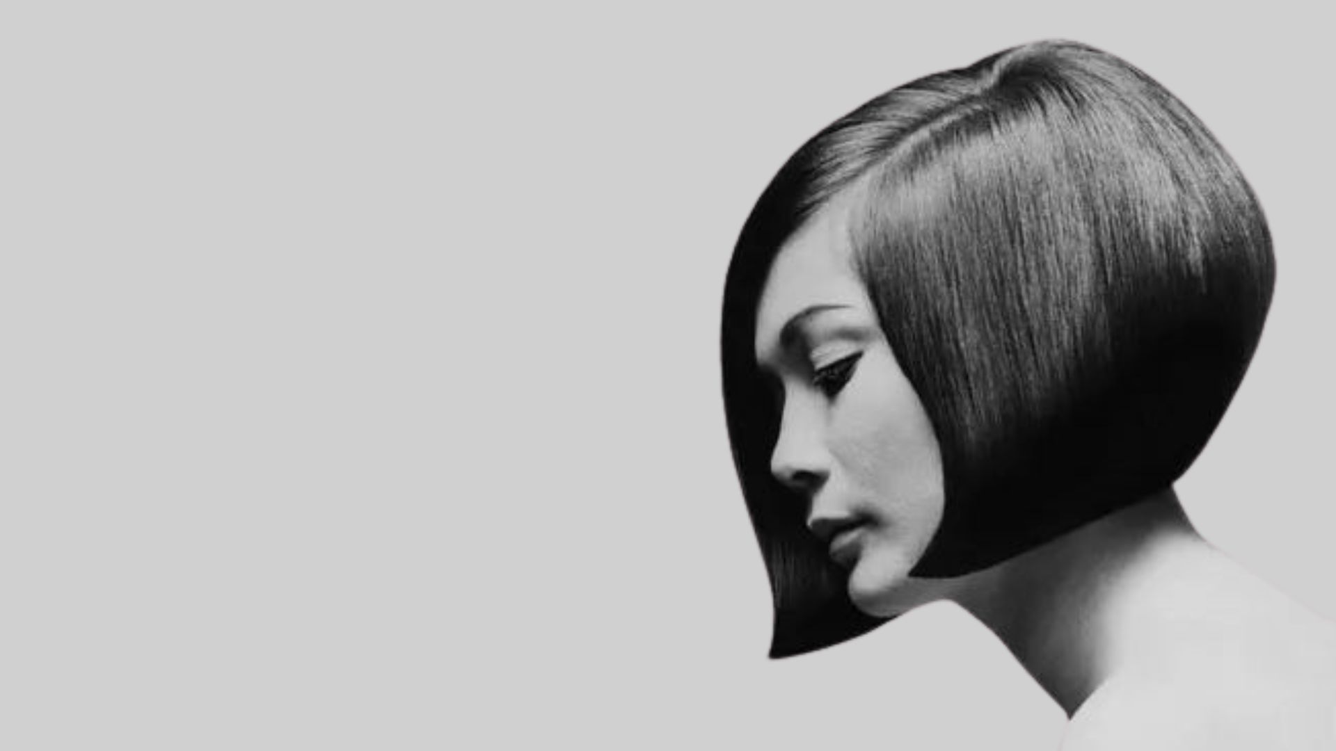 Profilo di una donna in bianco e nero con un iconico caschetto geometrico a punta, ispirazione Vidal Sassoon anni '60.