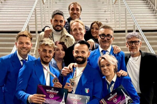 Parrucchieri della nazionale italiana celebrano la vittoria alla World Cup Hairworld con medaglie e diplomi.
