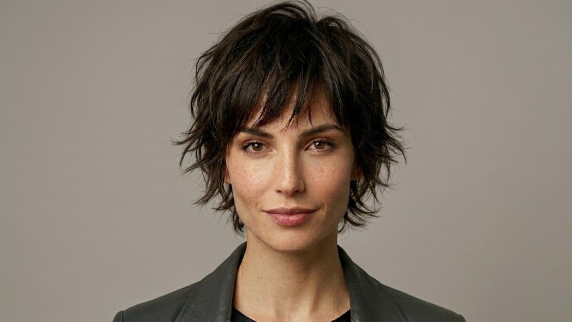 Modella con taglio Pixie Shaggy castano scuro, stile materico e scalato, tendenza capelli 2026.