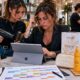 Titolare di salone e giovane hairstylist analizzano un tablet in un salone moderno, con prodotti solari professionali per capelli esposti sul banco.
