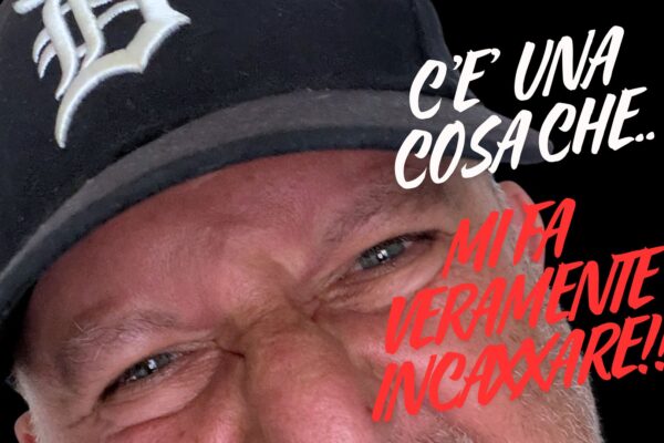 Primo piano ravvicinato di un uomo con un'espressione arrabbiata e accigliata, che indossa un berretto nero da baseball con il logo 'B'. Testo rosso sovrapposto: 'C'È UNA COSA CHE... MI FA VERAMENTE INCAZZARE!!!' su sfondo nero.