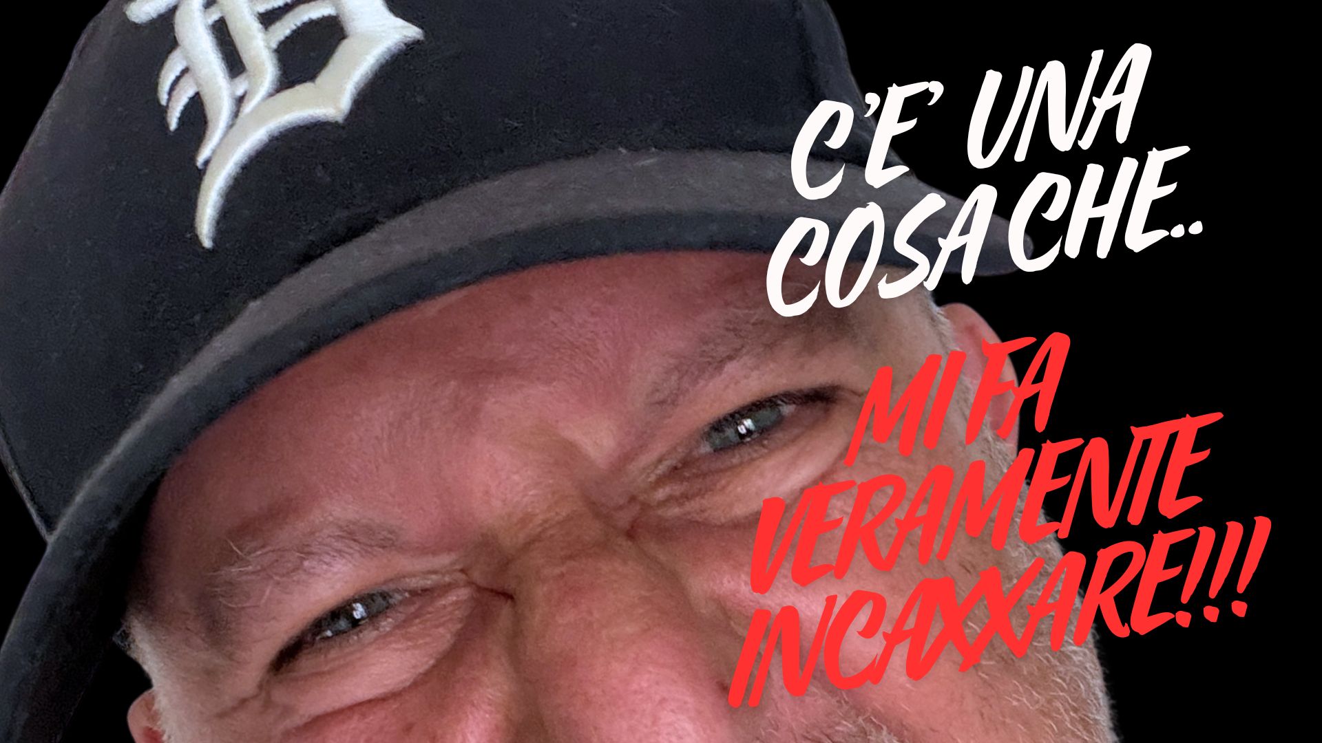 Primo piano ravvicinato di un uomo con un'espressione arrabbiata e accigliata, che indossa un berretto nero da baseball con il logo 'B'. Testo rosso sovrapposto: 'C'È UNA COSA CHE... MI FA VERAMENTE INCAZZARE!!!' su sfondo nero.