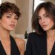 Una fotografia di livello professionale che mostra due donne con stili di capelli corti e scuri, affiancate all'interno di un salone di bellezza moderno e luminoso. La donna a sinistra sfoggia un taglio pixie sbarazzino e testurizzato, mentre la donna a destra ha un bob classico, liscio e arrotondato. Entrambe indossano capi neri eleganti.
