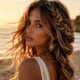 Capelli in vacanza: donna in spiaggia al tramonto con treccia olandese mossa dal vento