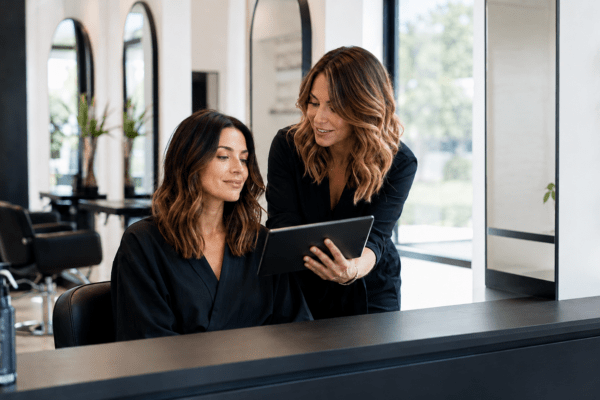 Hairstylist and client reviewing the desired result during a salon consultation