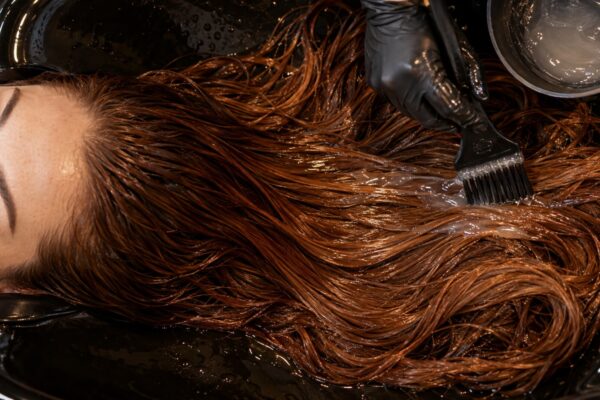 Capelli ramati lucidi durante il trattamento gloss di mantenimento in salone