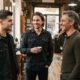 Three men wearing a soft taper, a medium flow and modern mullet haircut. AI-generated editorial image