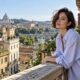 Donna con boyfriend bob mosso dal vento su un balcone in una città italiana