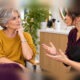 English salon price consultation: a silver-haired client and a hairstylist speaking in a salon, with both faces and hairstyles fully visible