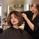 Professionista e cliente in salone; taglio e volti completamente visibili durante la valutazione della qualità di un servizio haircare