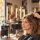Parrucchiera osserva i capelli sottili di una cliente in salone in autunno
