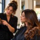 Hairstylist explaining a professional hair product to a client at the salon station
