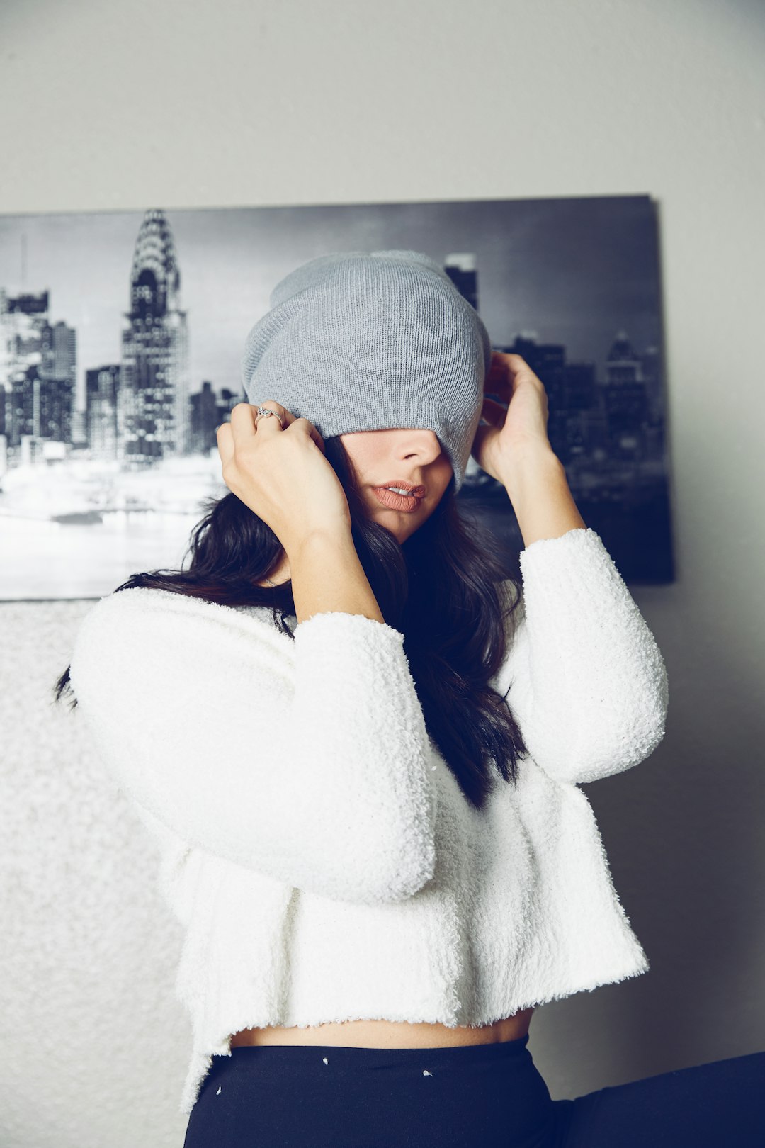 Donna con un berretto di lana grigio e un maglione chiaro.