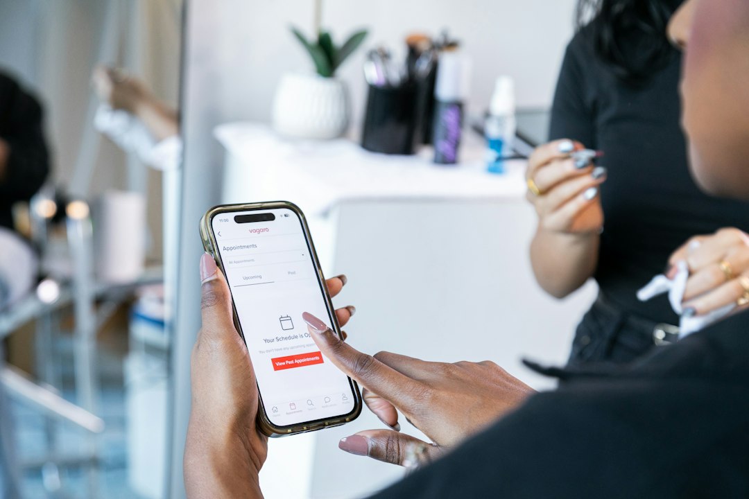Due mani tengono uno smartphone con una schermata di prenotazione.