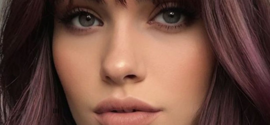 Donna con capelli color Cherry Cola, sfumature rosso ciliegia e marrone, look sofisticato e trendy.