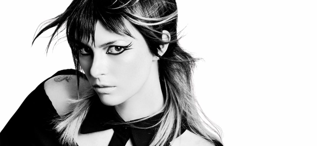 Black and white portrait of a model with graphic makeup and layered hair blown by the wind, part of The Mood Collection by Antonio Palladino.
