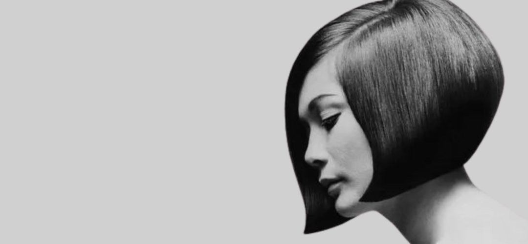 Profilo di una donna in bianco e nero con un iconico caschetto geometrico a punta, ispirazione Vidal Sassoon anni '60.