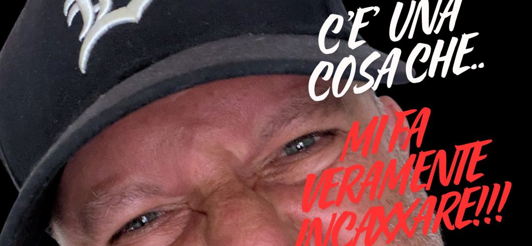 Primo piano ravvicinato di un uomo con un'espressione arrabbiata e accigliata, che indossa un berretto nero da baseball con il logo 'B'. Testo rosso sovrapposto: 'C'È UNA COSA CHE... MI FA VERAMENTE INCAZZARE!!!' su sfondo nero.