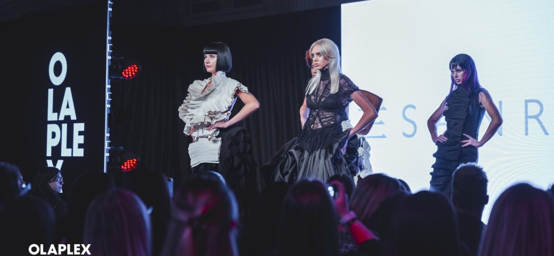 Modelle sul palco durante il Live Hair Cutting Show Olaplex Pro; loghi OLAPLEX e CALENDA leggibili in basso a sinistra.